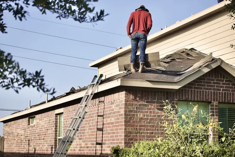 Professional roofer working on a residential roof in Overton